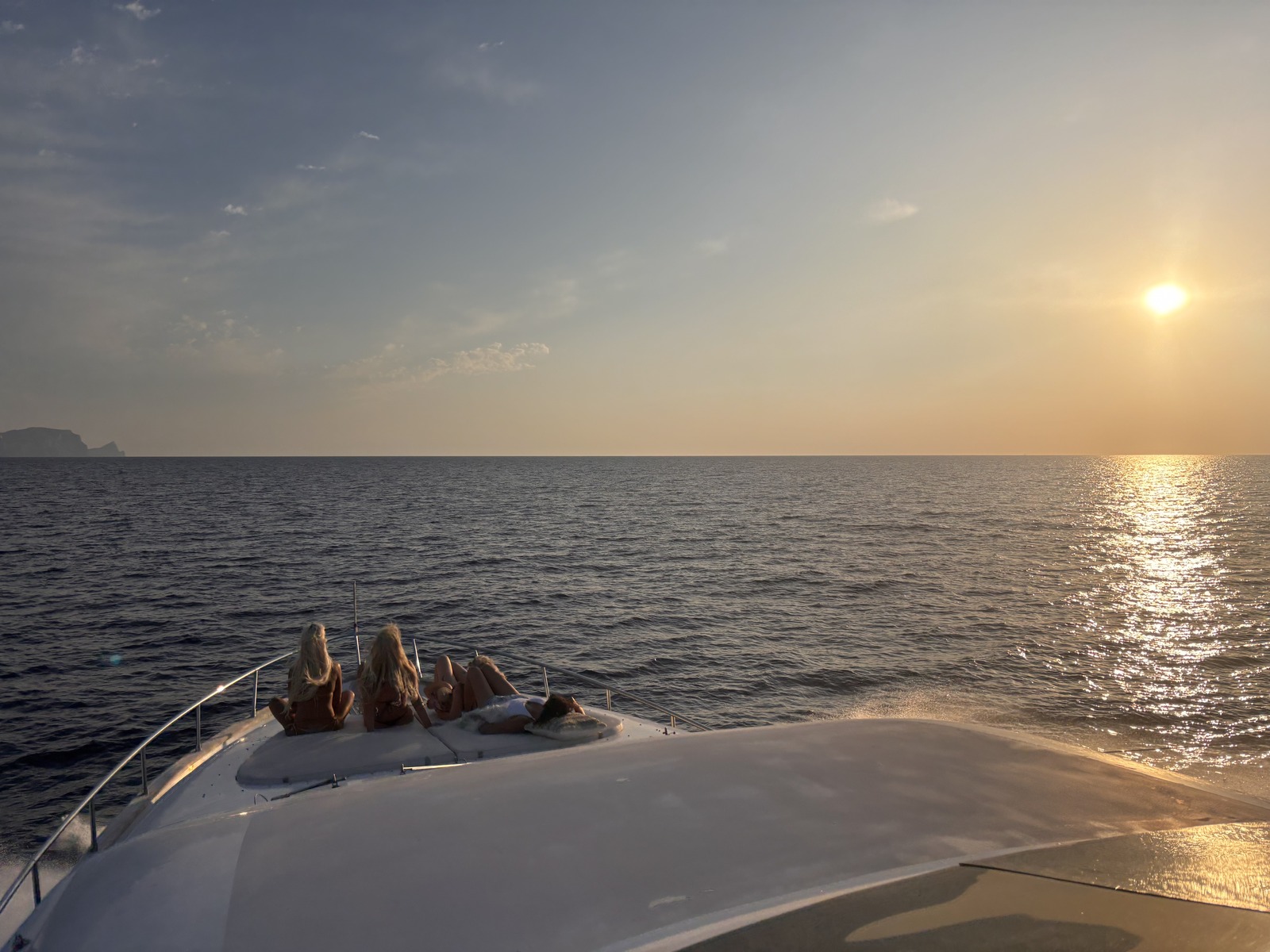 Guests on the bow watching the sun set over the Mediterranean